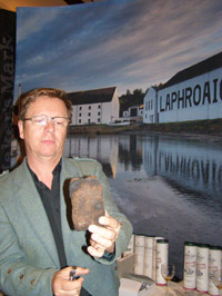 Lighting a piece of Peat at Laphroaig Whisky booth at Whisky Live New York - Photo by Luxury Experience