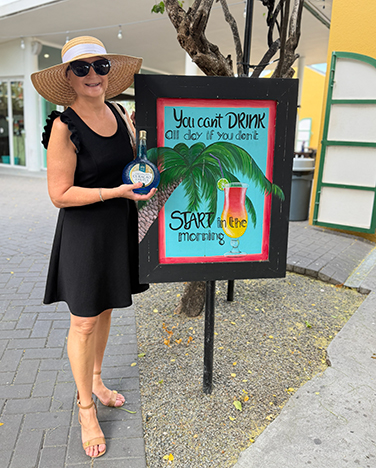 Debra C. Argen - with Curaçao Liqueur Sign - photo by Luxury Experience